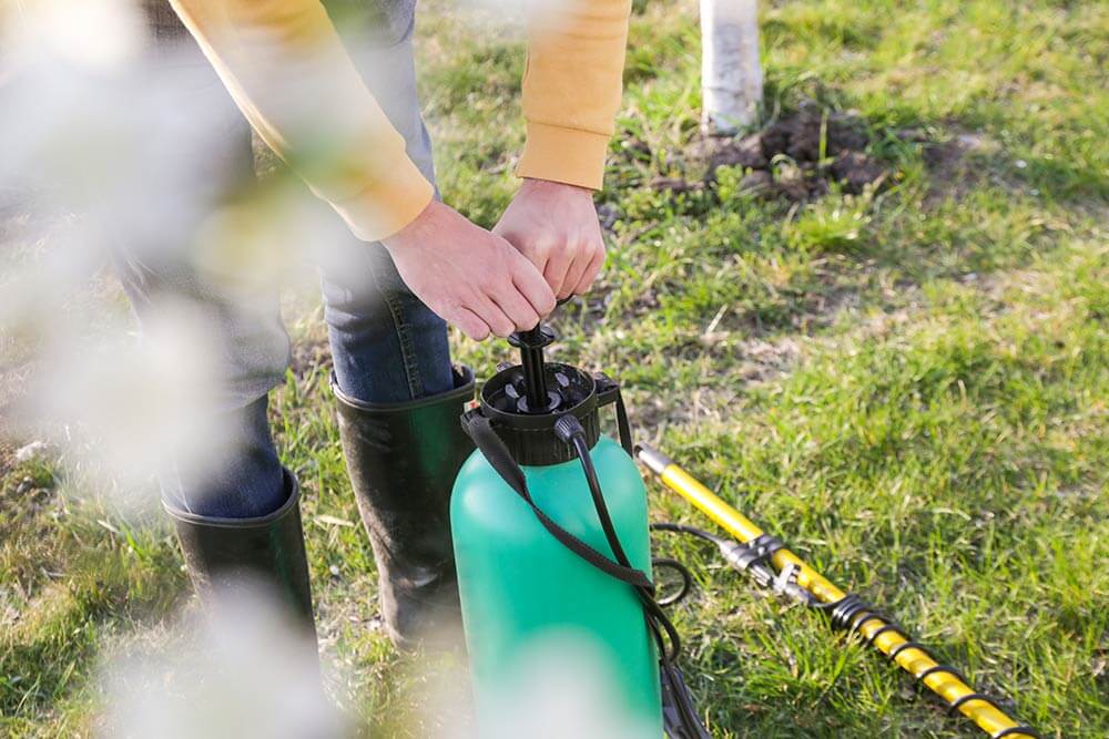 Tips & Tricks to prepare for the season, hands pumping green sprayer outside